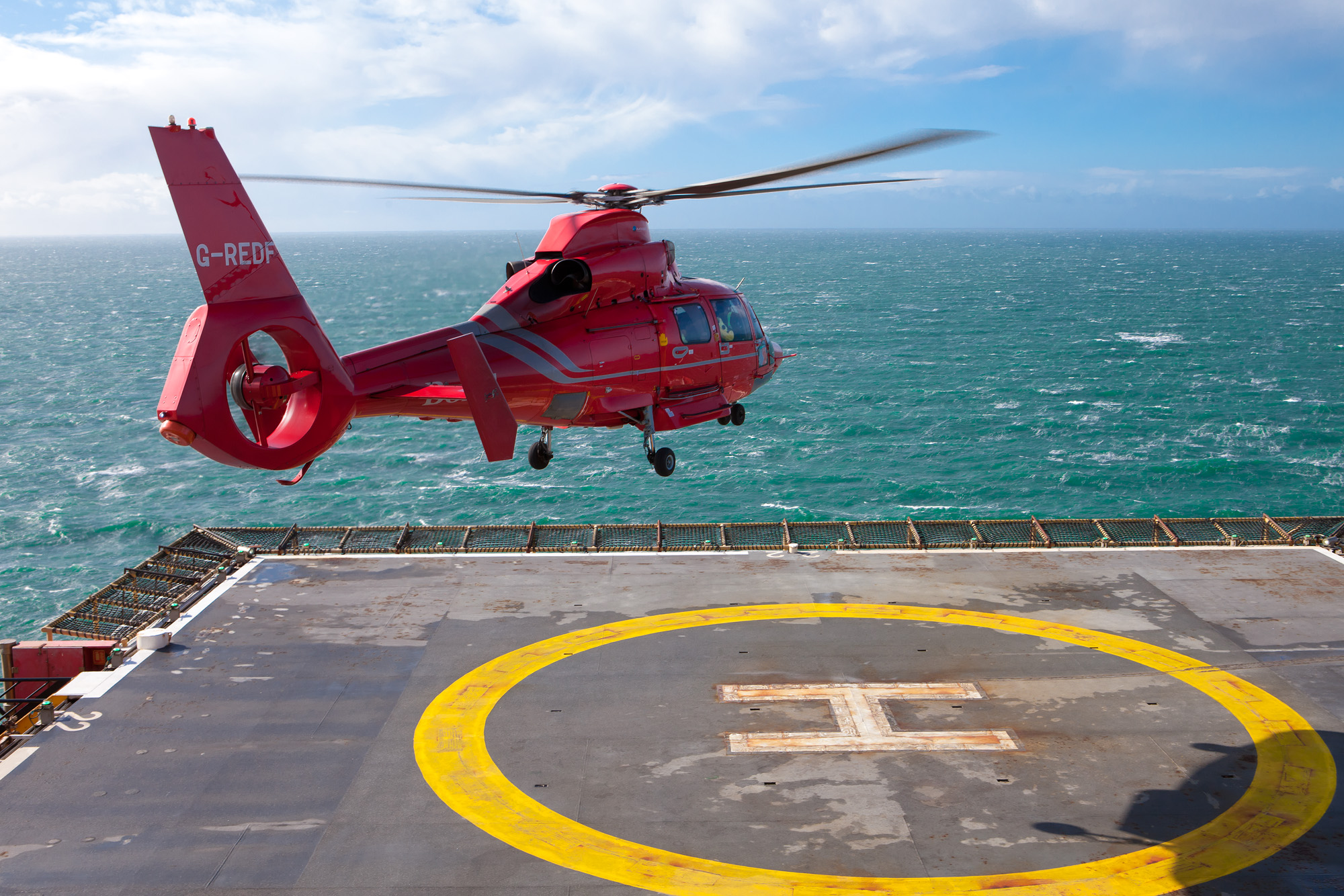 Aerospatiale AS365 Dauphin II helicopter landing on a gas rig helipad, Irish Sea